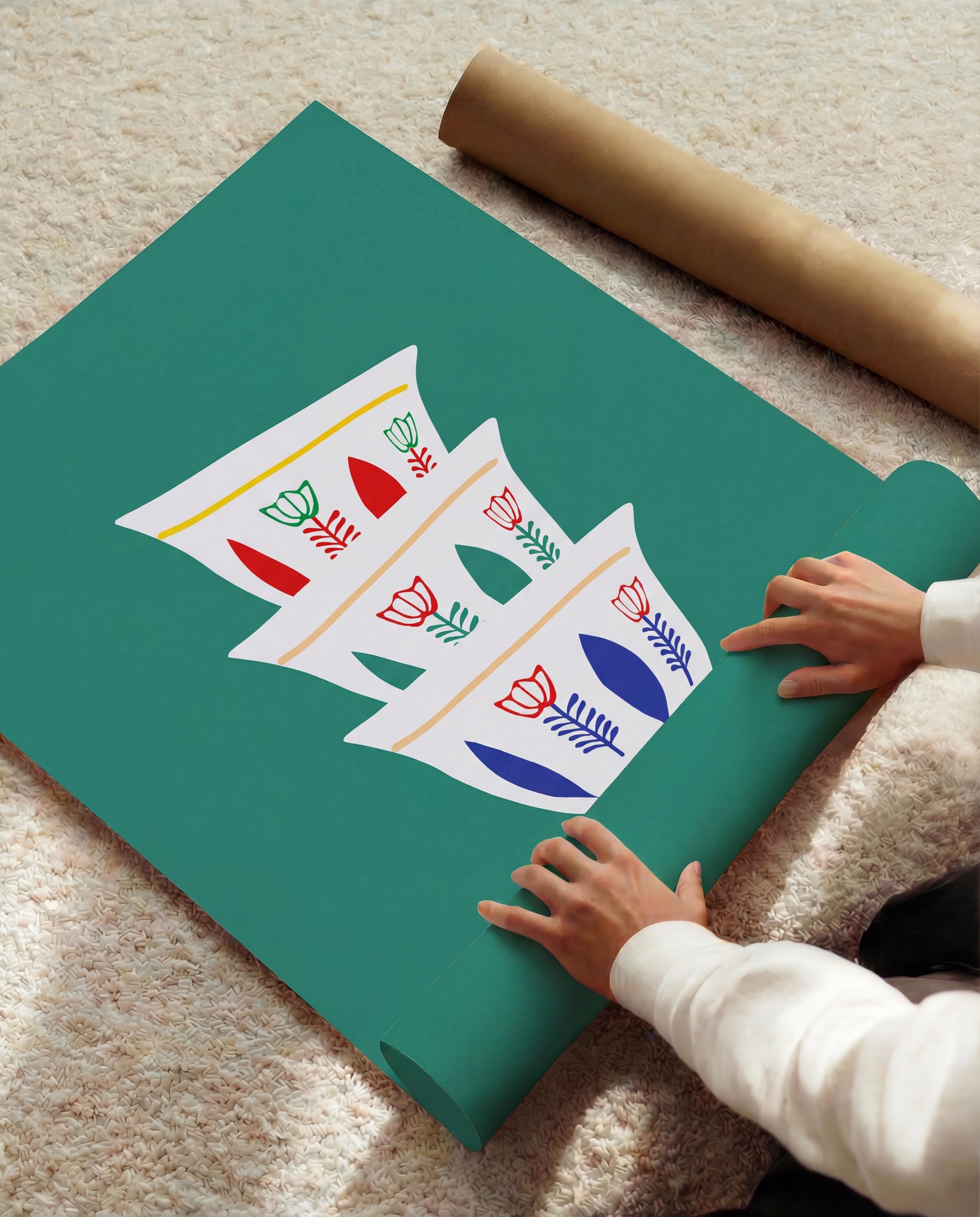 A teal-colored poster featuring a stack of three white coffee cups with floral designs in red, green, and blue. The poster is partially rolled out, with a brown paper tube visible in the background. The image is set on a light-colored rug.