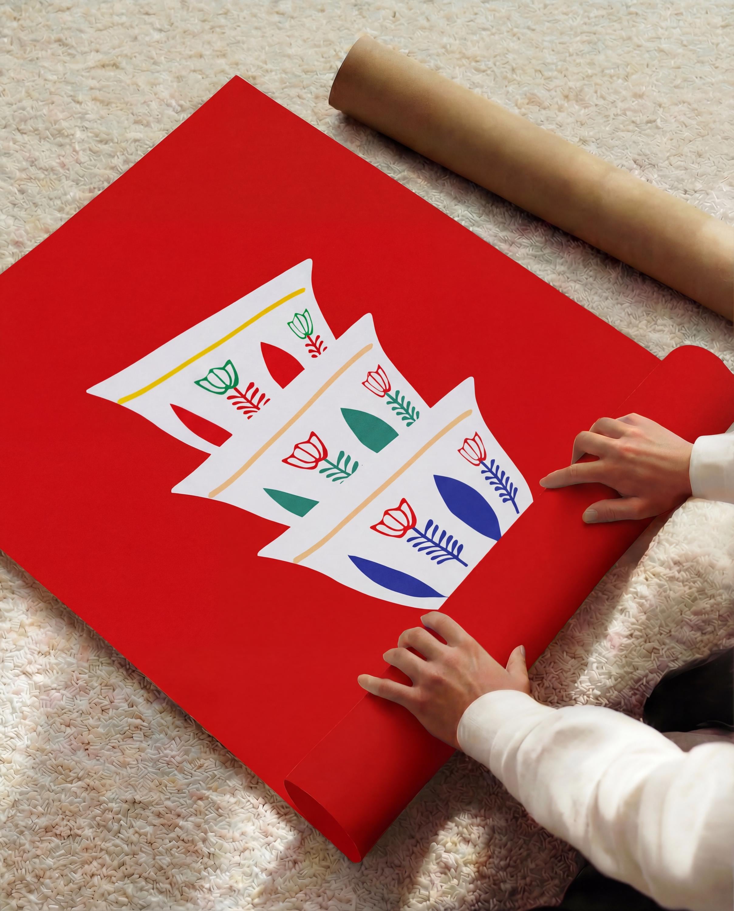 A red poster with a white design of three stylized coffee cups with floral patterns in green, red, and blue. A rolled-up brown paper tube is visible in the background.